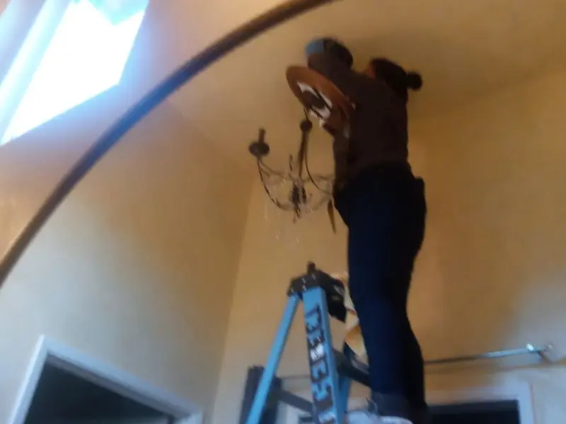 Electrician installing a chandelier in a Prescott residence